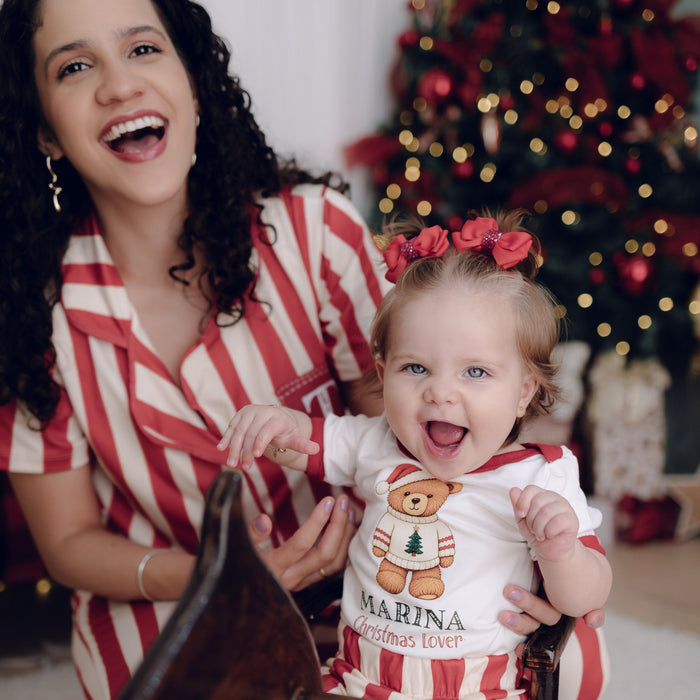 Mãe de pijama listrado com bebê no colo
