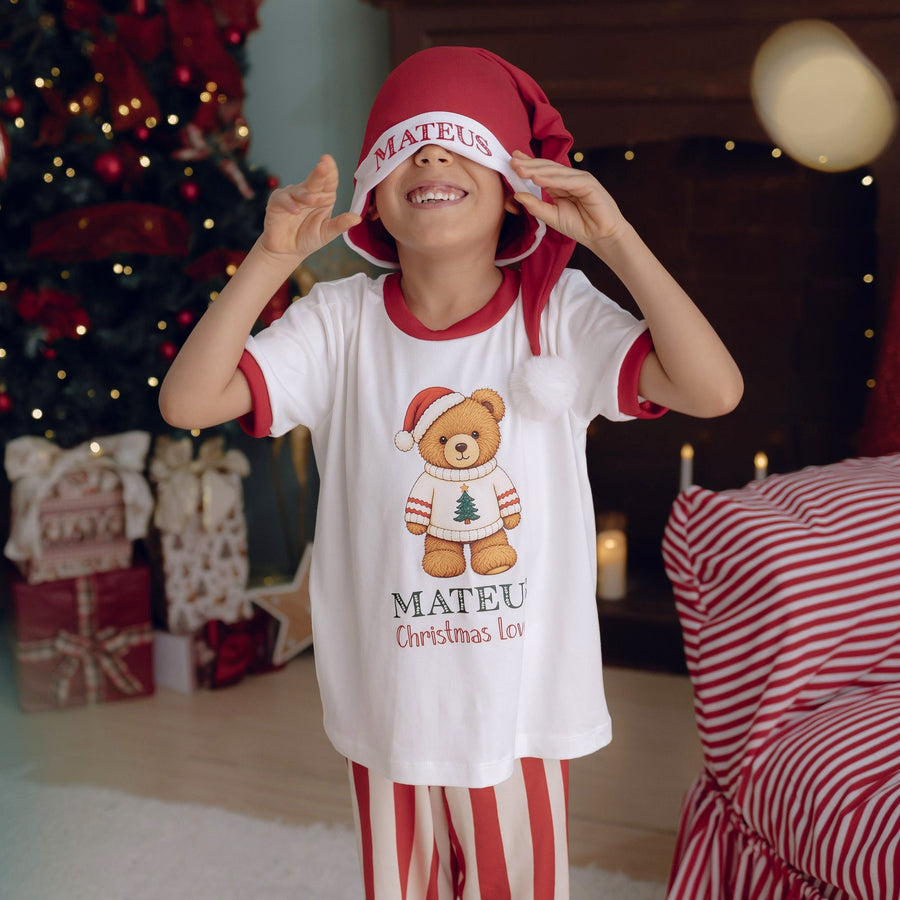 Menino de pijama Christmas Lover sorrindo com gorro de Natal