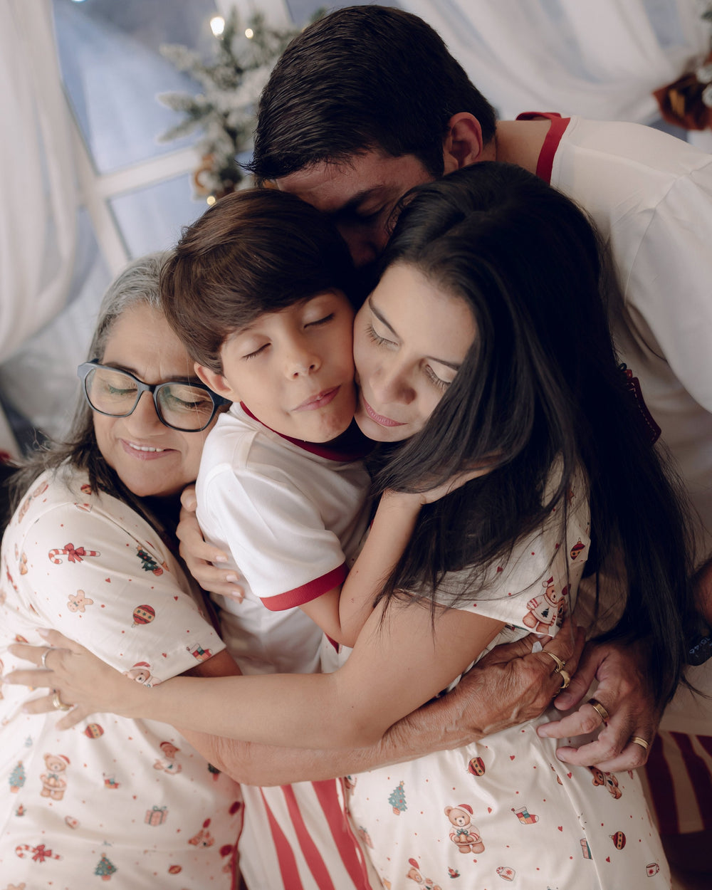 Mãe abraçando os filhos, todos de pijama da coleção